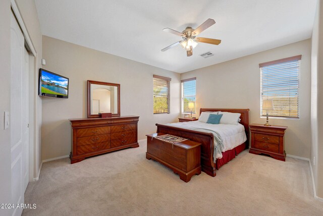 bedroom featuring a closet, ceiling fan, and light colored carpet