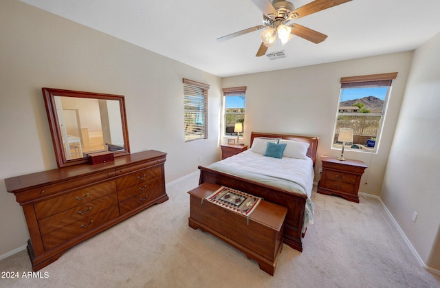 carpeted bedroom featuring multiple windows and ceiling fan