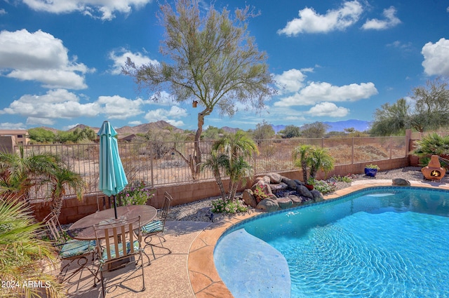 view of pool featuring a mountain view, a patio, and pool water feature