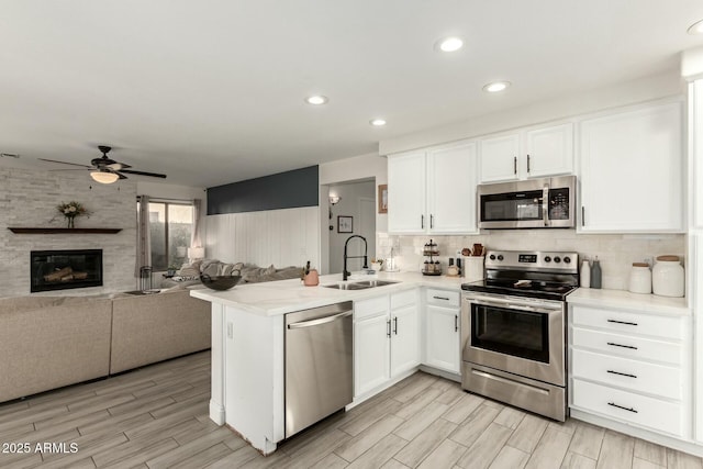 kitchen with appliances with stainless steel finishes, white cabinets, and a sink