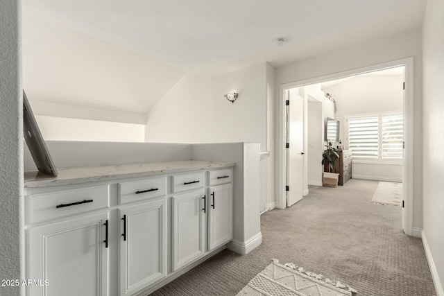 bathroom featuring vaulted ceiling and baseboards