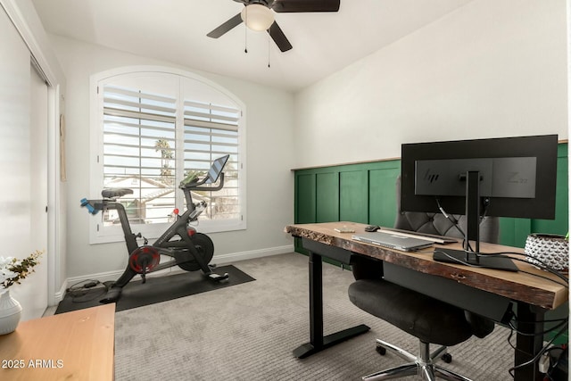 office featuring a ceiling fan, light colored carpet, and baseboards