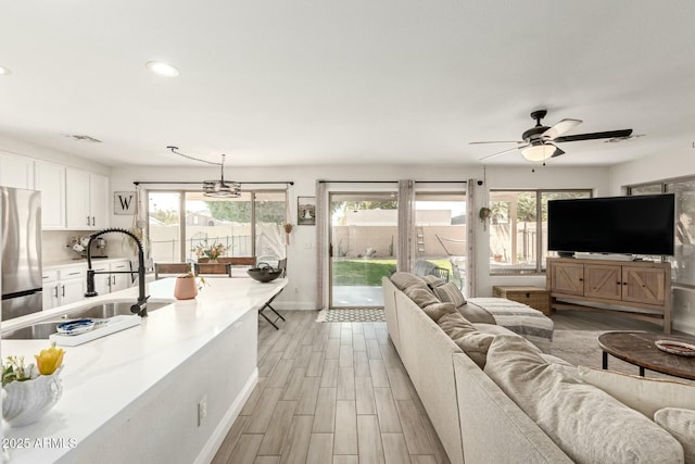 living room featuring a healthy amount of sunlight, light wood-style floors, baseboards, and visible vents