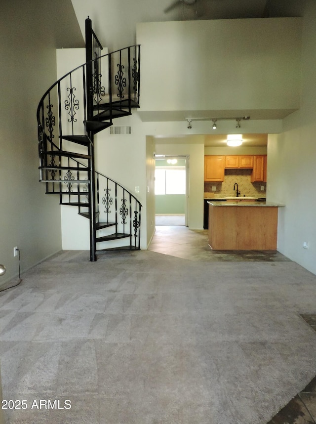 30 E Brown Rd Unit 2113, Mesa, AZ 85201 - unfurnished living room with stairs, light colored carpet, a high ceiling, and track lighting