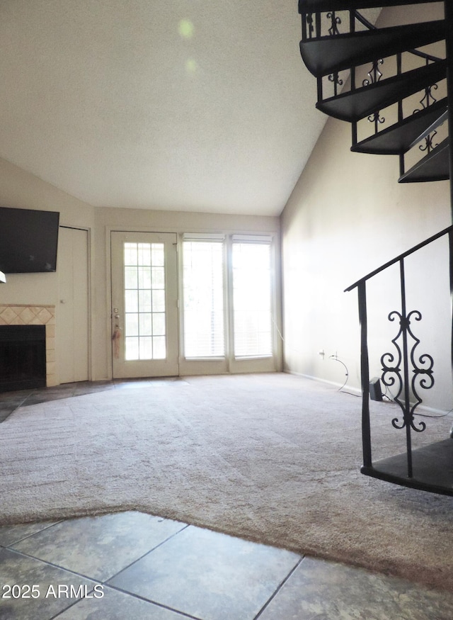 30 E Brown Rd Unit 2113, Mesa, AZ 85201 - unfurnished living room with carpet, vaulted ceiling, healthy amount of natural light, and a tile fireplace
