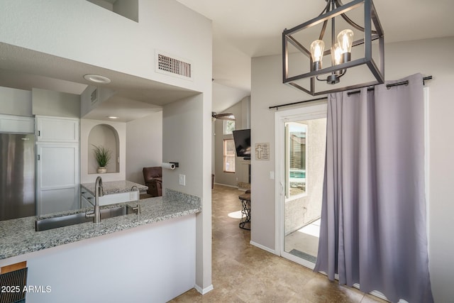 bathroom featuring a notable chandelier, visible vents, baseboards, and a sink