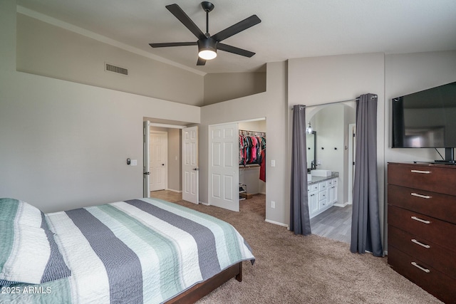 bedroom with visible vents, a walk in closet, a closet, carpet floors, and lofted ceiling