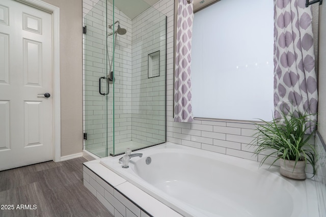 full bathroom with wood finished floors, a garden tub, and a stall shower