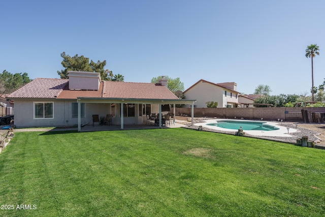 back of property featuring a patio, a yard, a fenced backyard, and a tile roof