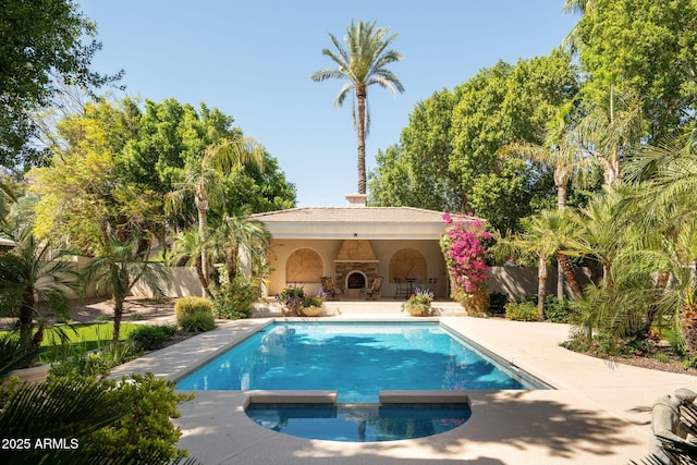 view of swimming pool with fence, a pool with connected hot tub, and a patio area