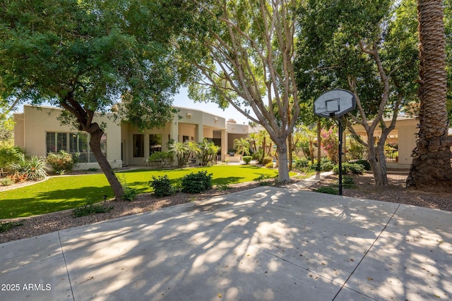 view of sport court featuring a yard and basketball hoop