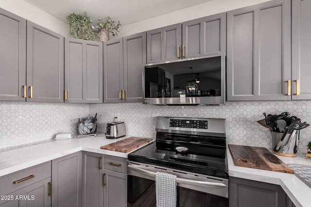 9265 E Kalil Dr, Scottsdale, AZ 85260 - kitchen with stainless steel appliances, gray cabinets, tasteful backsplash, and ceiling fan