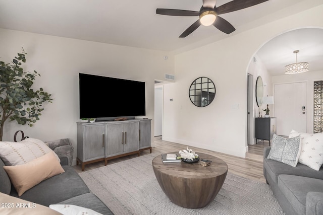 9265 E Kalil Dr, Scottsdale, AZ 85260 - living area featuring vaulted ceiling, light wood-style floors, arched walkways, a ceiling fan, and a chandelier