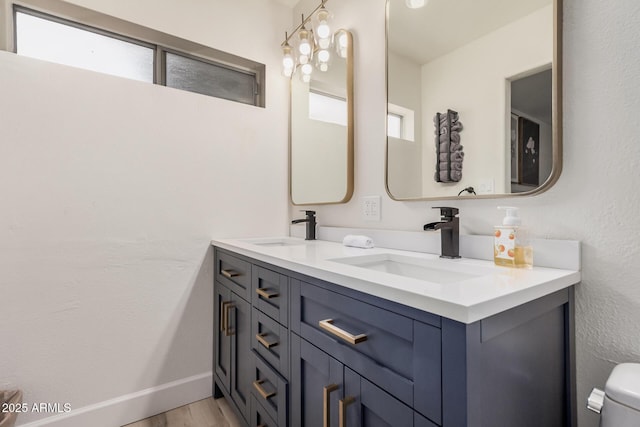 9265 E Kalil Dr, Scottsdale, AZ 85260 - bathroom with double vanity, wood finished floors, toilet, and baseboards