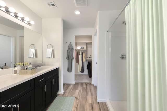 bathroom featuring vanity, wood-type flooring, and a shower