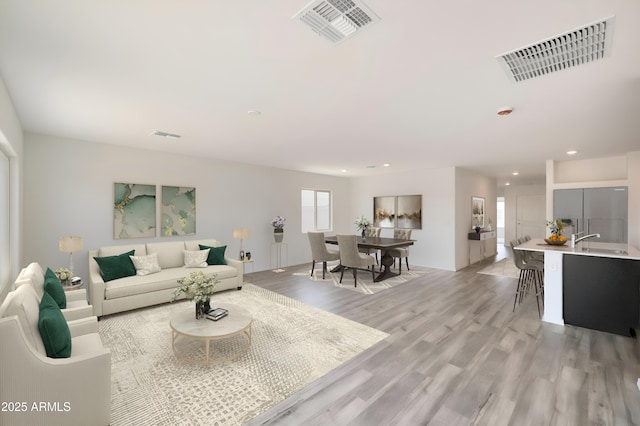 living room featuring sink and light wood-type flooring