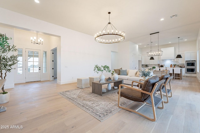 living room featuring recessed lighting, a notable chandelier, visible vents, and light wood-type flooring