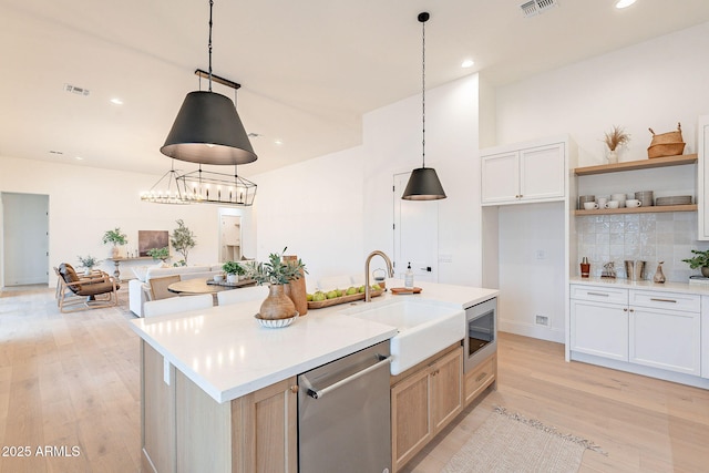 kitchen featuring a sink, light countertops, light wood-style floors, and stainless steel appliances