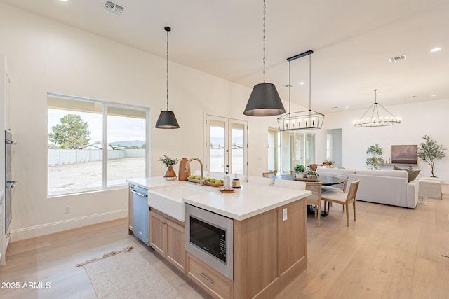 kitchen with light wood-style floors, visible vents, appliances with stainless steel finishes, and a sink