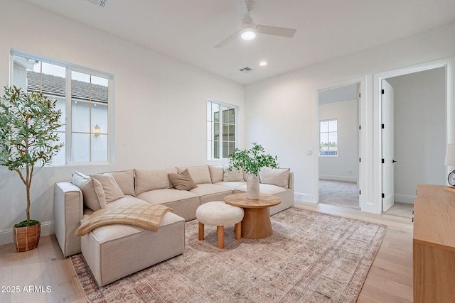 living room featuring visible vents, baseboards, ceiling fan, light wood-type flooring, and recessed lighting