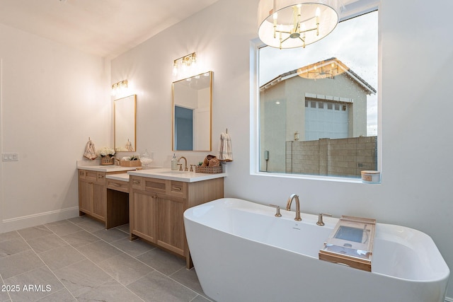 bathroom with baseboards, a soaking tub, and vanity