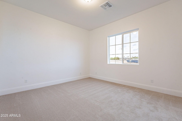 unfurnished room featuring light colored carpet, visible vents, and baseboards