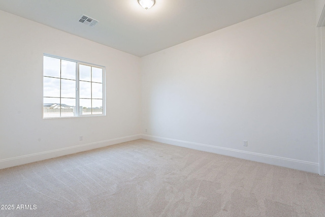 empty room with visible vents, baseboards, and light colored carpet