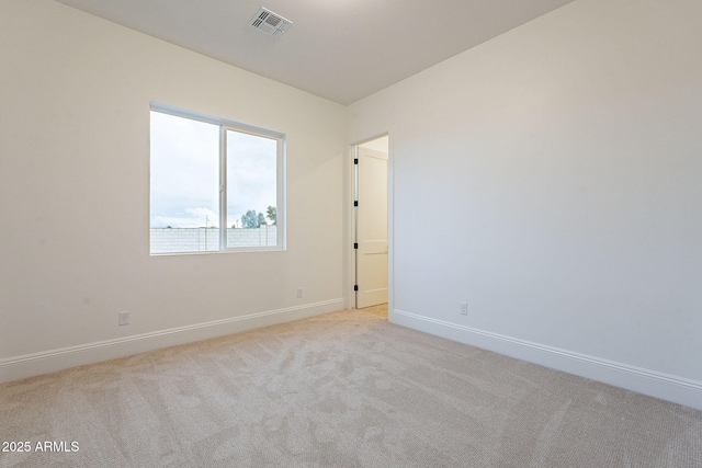 unfurnished room featuring visible vents, baseboards, and light colored carpet