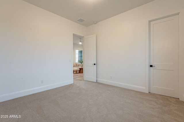 unfurnished room featuring visible vents, light colored carpet, and baseboards