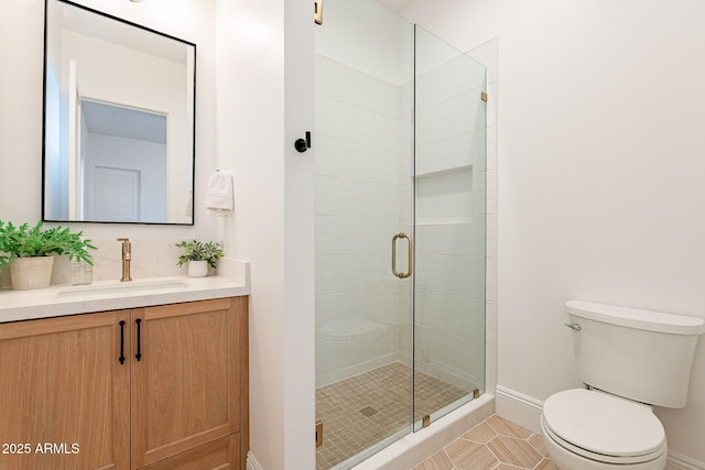 full bath featuring a shower stall, toilet, vanity, and baseboards