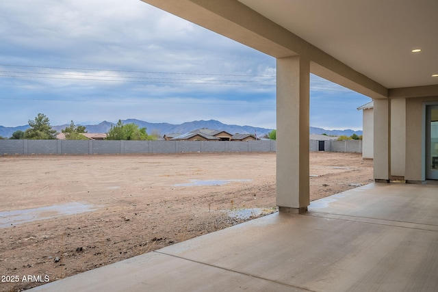 view of yard with a patio area, a mountain view, and a fenced backyard