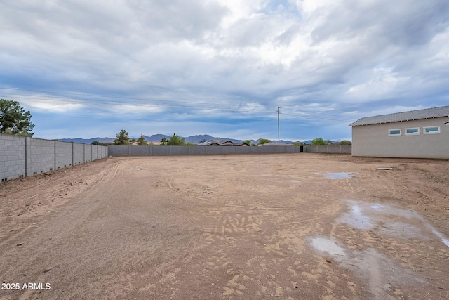 view of yard featuring a mountain view and fence