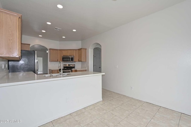 kitchen with arched walkways, visible vents, stainless steel appliances, and a sink