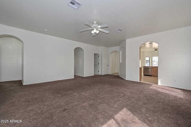 unfurnished living room featuring visible vents, arched walkways, and a ceiling fan