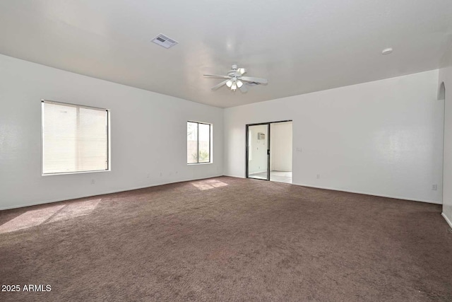 carpeted empty room featuring a ceiling fan and visible vents