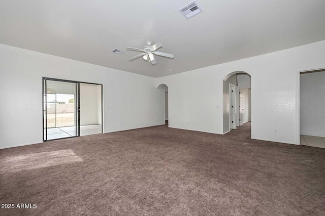 carpeted empty room featuring visible vents, arched walkways, and ceiling fan