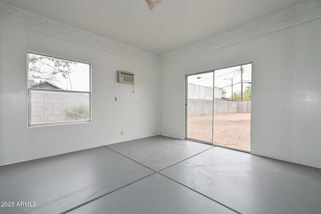 spare room with an AC wall unit and concrete floors