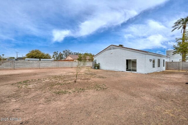 exterior space with stucco siding and a fenced backyard