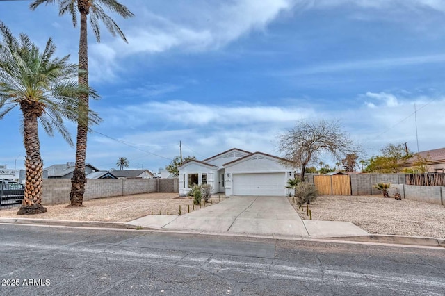 view of front of house featuring a fenced front yard, driveway, an attached garage, and a gate