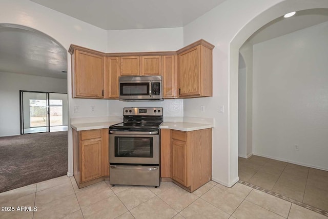 kitchen featuring light tile patterned floors, stainless steel appliances, and light countertops