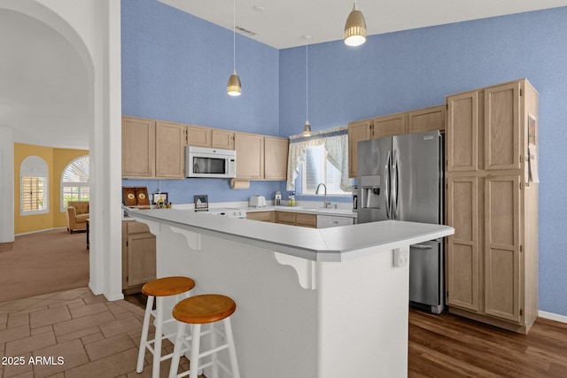 16002 E Gleneagle Dr, Fountain Hills, AZ 85268 - kitchen with white appliances, a towering ceiling, light brown cabinets, light countertops, and a kitchen breakfast bar