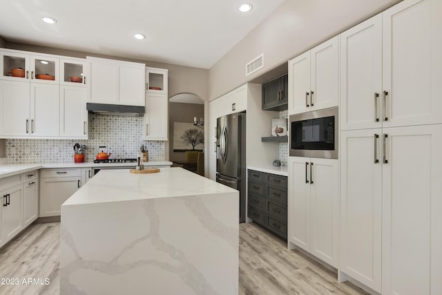 29771 N 67th St, Scottsdale, AZ 85266 - kitchen with decorative backsplash, visible vents, stainless steel fridge, built in microwave, and a center island