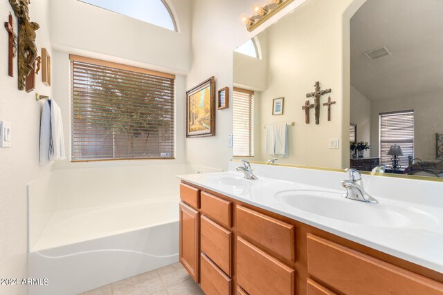 bathroom with dual vanity, a washtub, plenty of natural light, and tile patterned floors