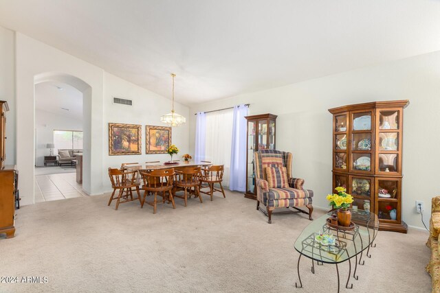 dining space featuring a notable chandelier, lofted ceiling, and light carpet