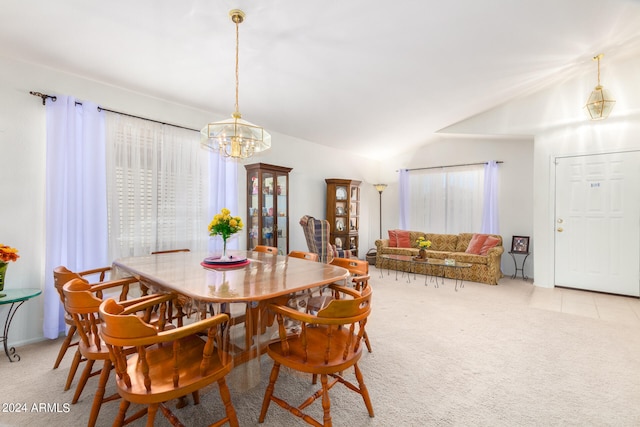 carpeted dining area with lofted ceiling, a notable chandelier, and plenty of natural light