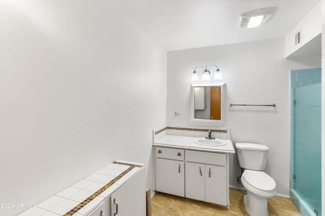 bathroom with vanity, toilet, a shower, and tile patterned floors