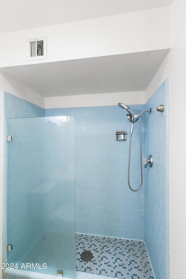 bathroom with a stall shower and visible vents