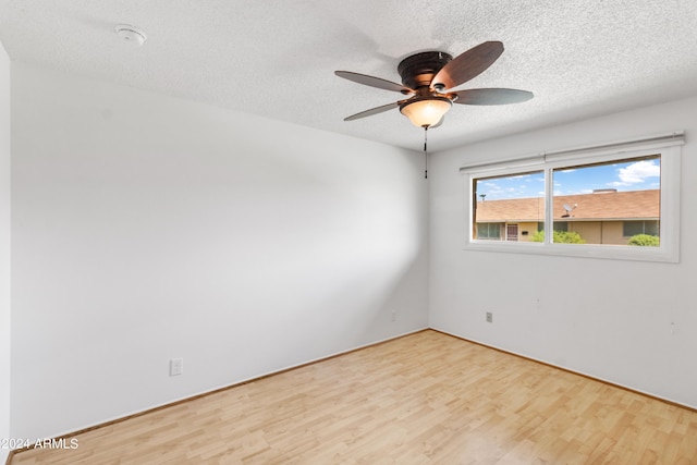 unfurnished room featuring a textured ceiling, wood finished floors, and a ceiling fan