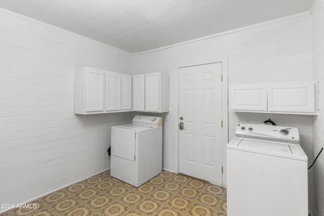 clothes washing area with light tile patterned flooring, cabinet space, and washer and dryer