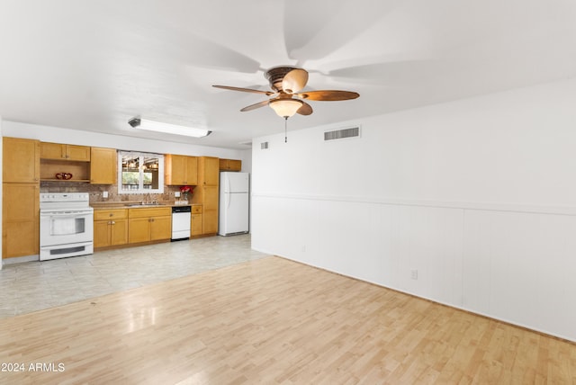 unfurnished living room featuring visible vents, wainscoting, ceiling fan, light wood-type flooring, and a sink